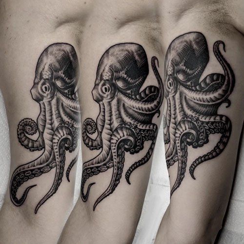 A black and white octopus tattoo on a person 's leg